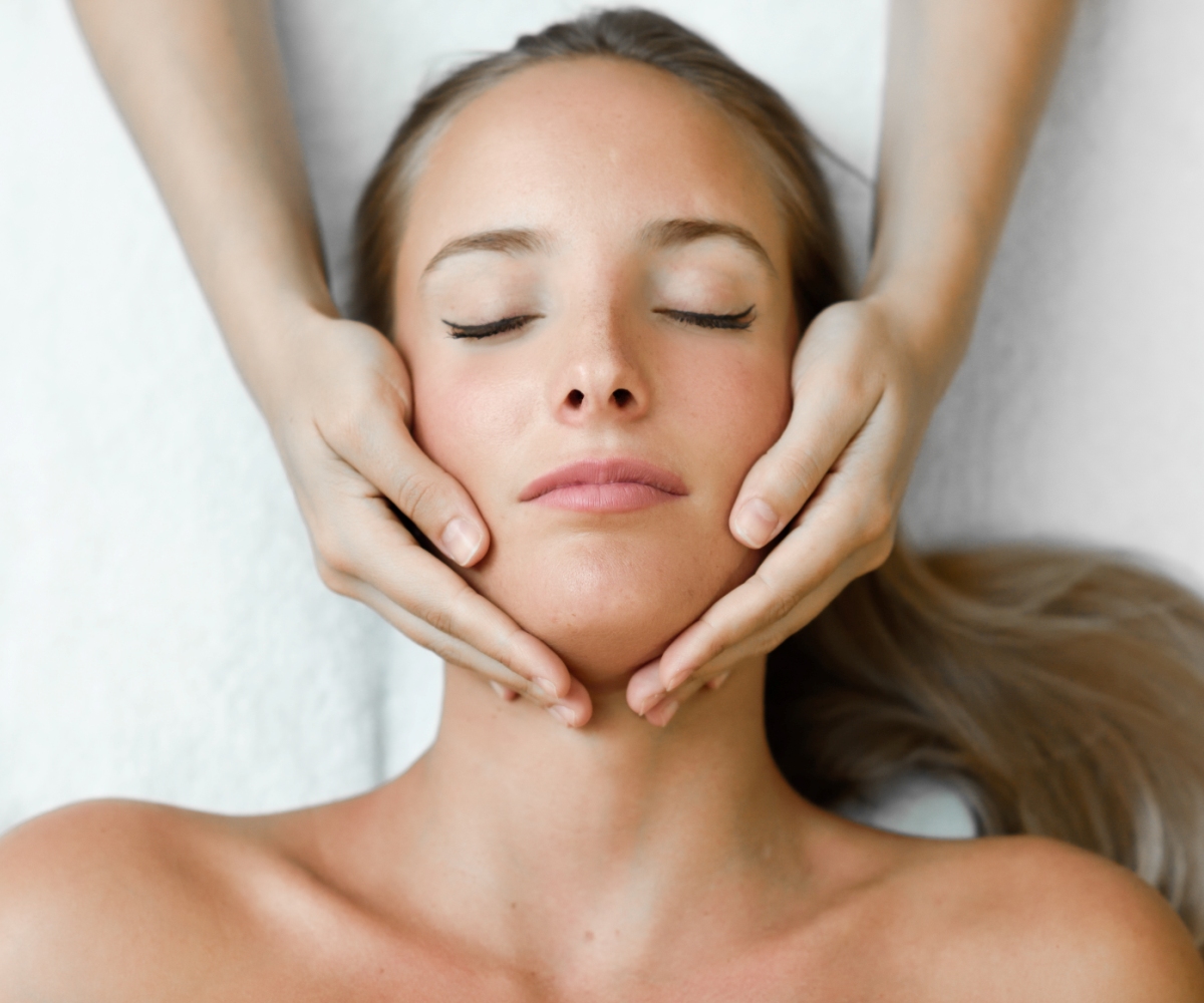 Young woman receiving a head massage in a spa center.